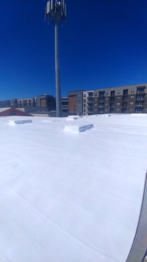 Spray polyurethane foam roofing system on commercial building